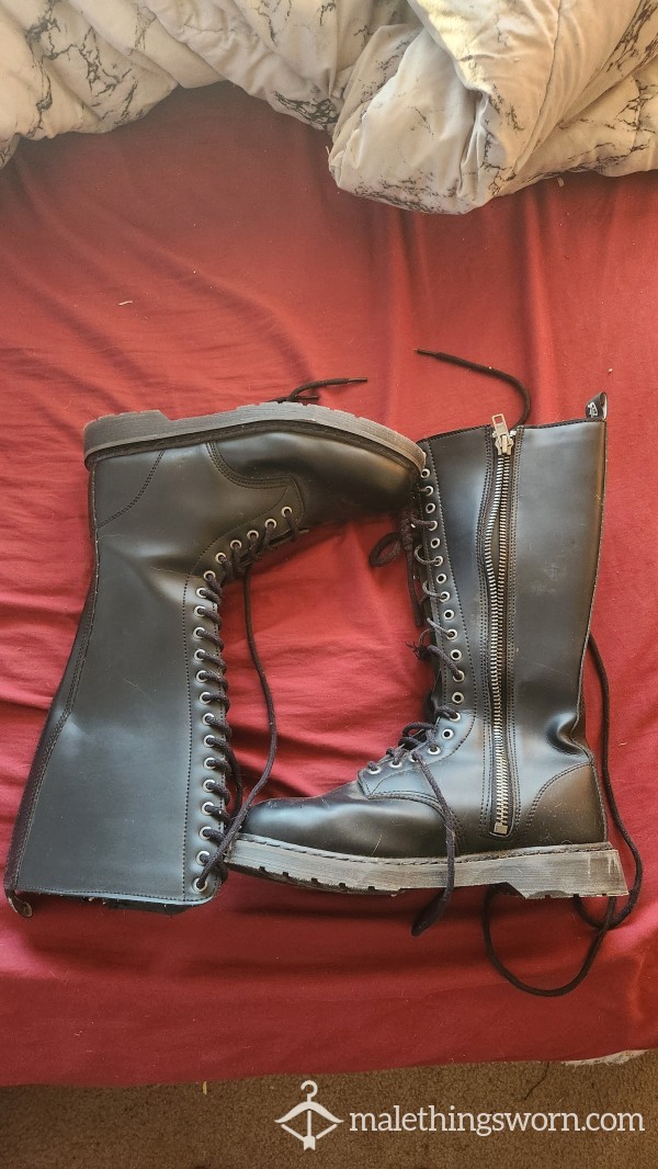 A Pair Of Black Knee High Lace Up And Zip Up Boots.