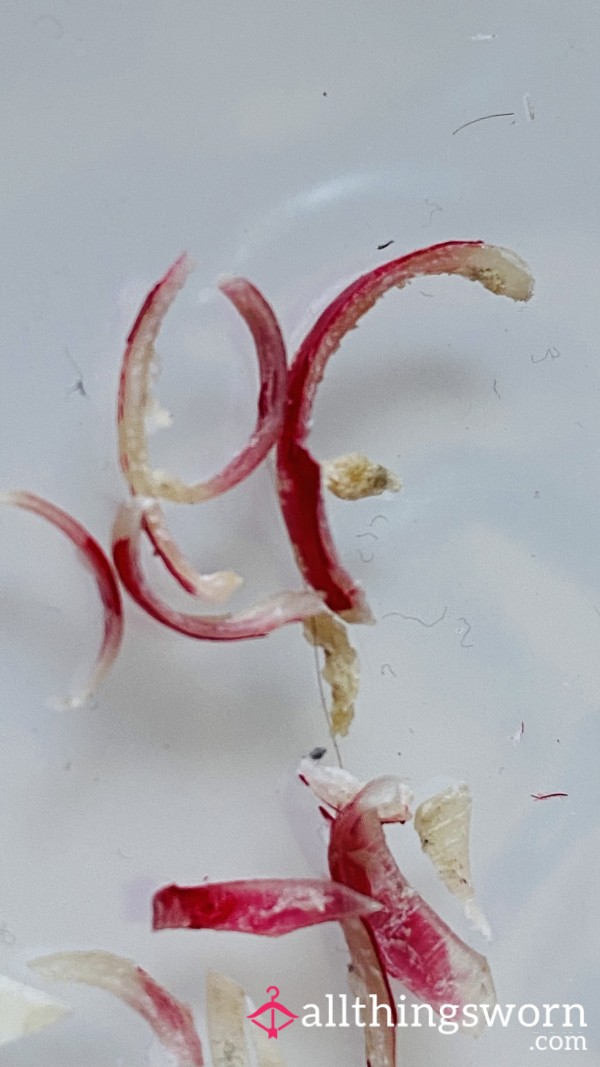 Curved Slivers Of Crimson-stained Toenails And Shimmering Fingernails Clippings