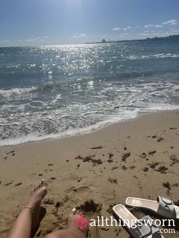 Gorgeous Brown Feet With Decorated White Toenails On A Beach