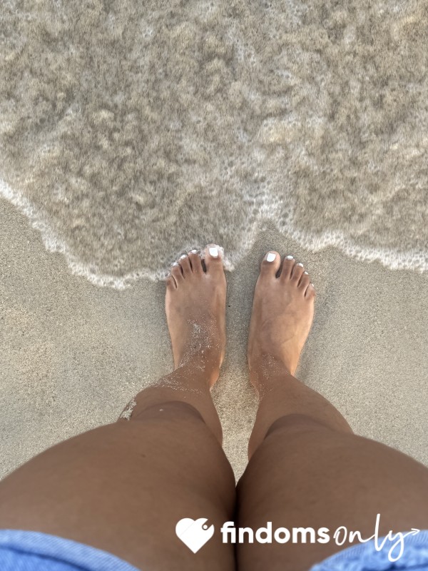 Wet Feet Touching Sand And Sea Water